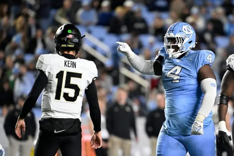 Nov 16, 2024; Chapel Hill, North Carolina, USA; North Carolina Tar Heels defensive lineman Travis Shaw (4) reacts after making a tackle as Wake Forest Demon Deacons quarterback Michael Kern (15) looks to the sideline in the third quarter at Kenan Memorial Stadium. Mandatory Credit: Bob Donnan-Imagn Images