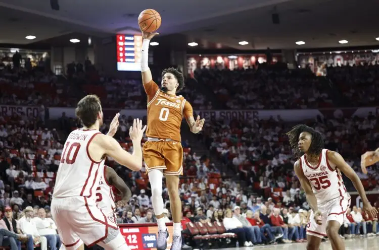 Jan 15, 2025; Norman, Oklahoma, USA; Texas Longhorns guard Jordan Pope (0) shoots over Oklahoma Sooners forward Sam Godwin (10) during the first half at Lloyd Noble Center. Mandatory Credit: Alonzo Adams-Imagn Images
