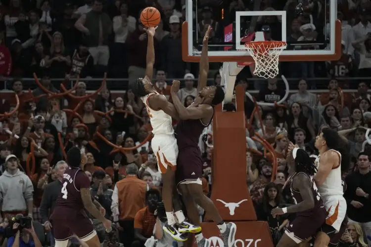 Jan 25, 2025; Austin, Texas, USA; Texas Longhorns guard Tramon Mark (12) shoots the winning shot over Texas A&M Aggies forward Pharrel Payne (21) with three seconds left in the game at Moody Center. Mandatory Credit: Scott Wachter-Imagn Images