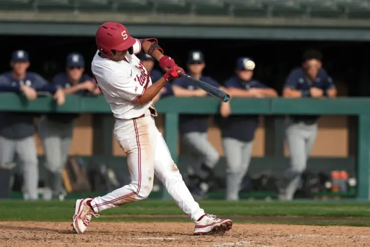 Feb 28, 2025; Stanford, CA, USA; Stanford Cardinal shortstop Temo Becerra (2) hits an RBI sacrifice fly against the Xavier Musketeers during the sixth inning at Sunken Diamond. Mandatory Credit: Darren Yamashita-Imagn Images